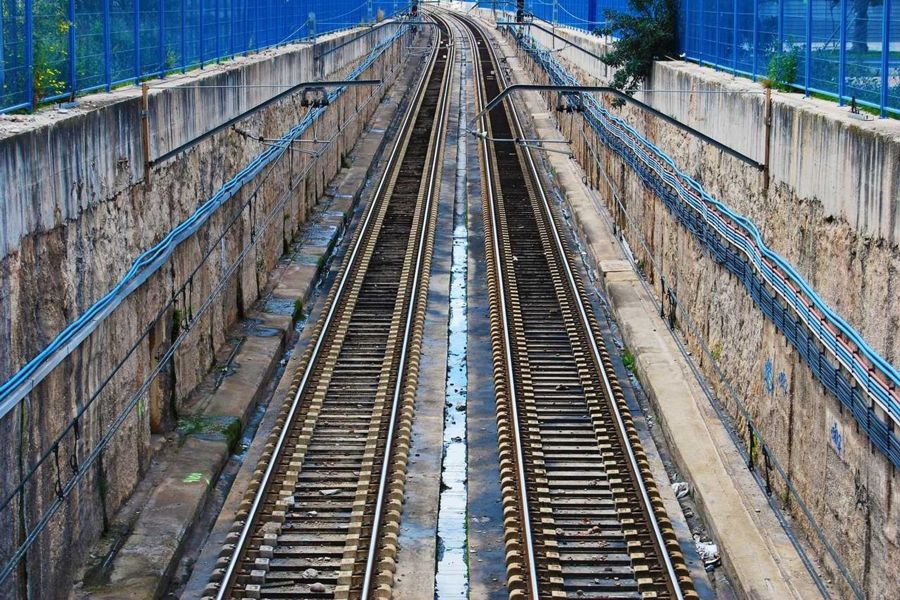 Twin railway tracks in a concrete cutting seen from above